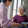 Man walks with the assistance of a walker and a home care specialist